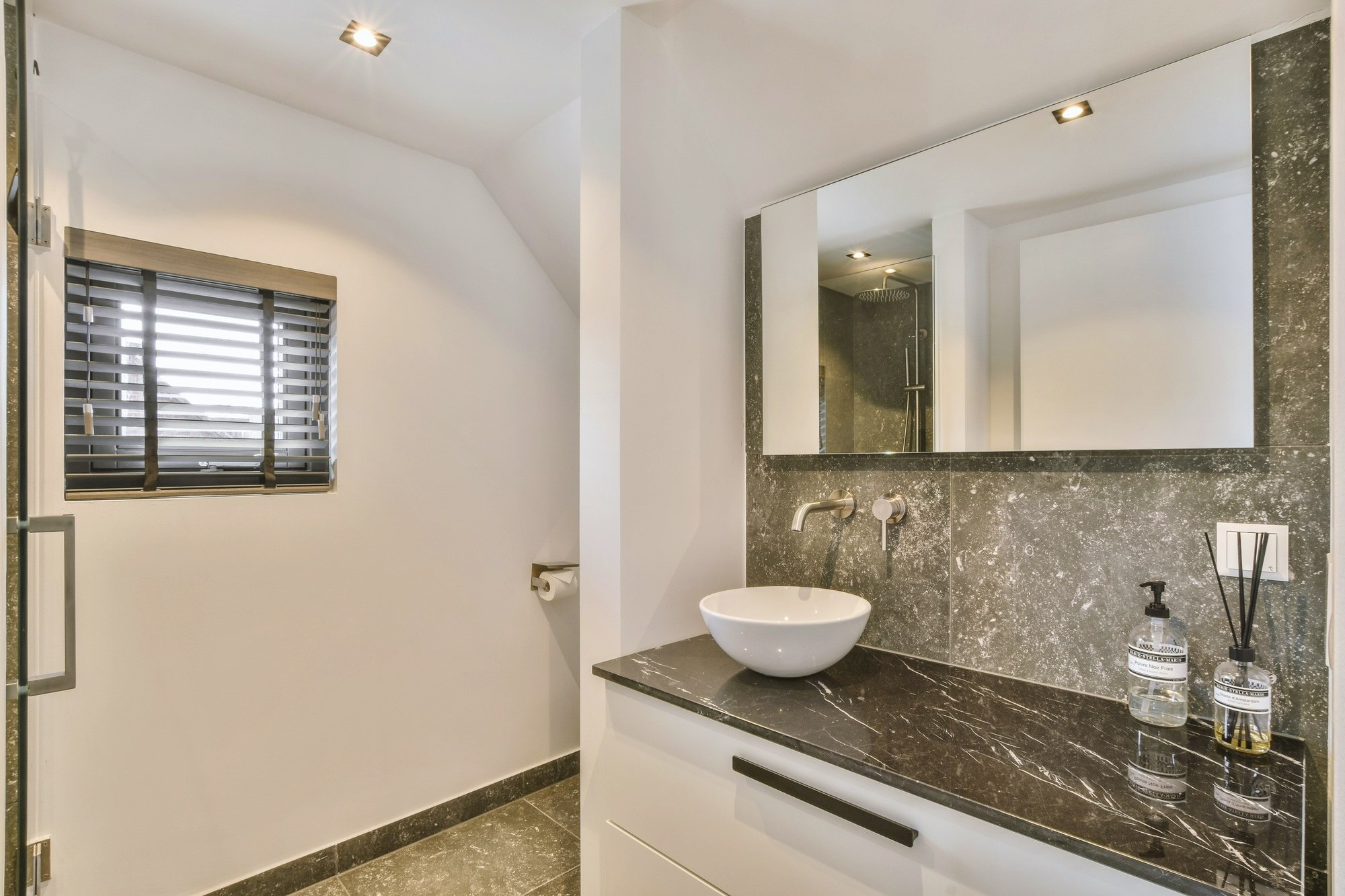 Open shower in gray tiled room
