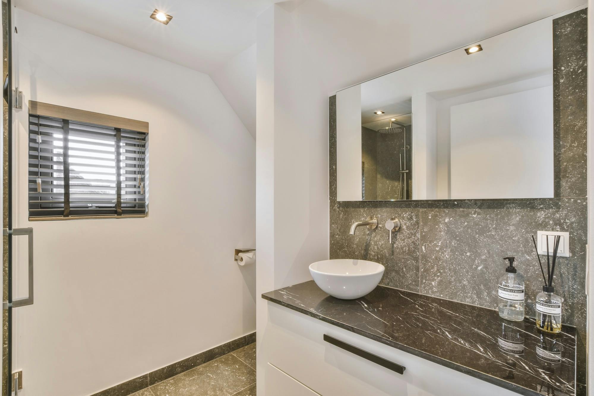 Open shower in gray tiled room